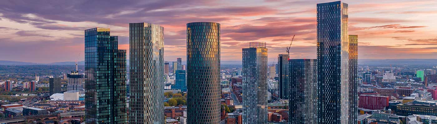 Aerial view of skyscrapers in Manchester City Centre at dawn.